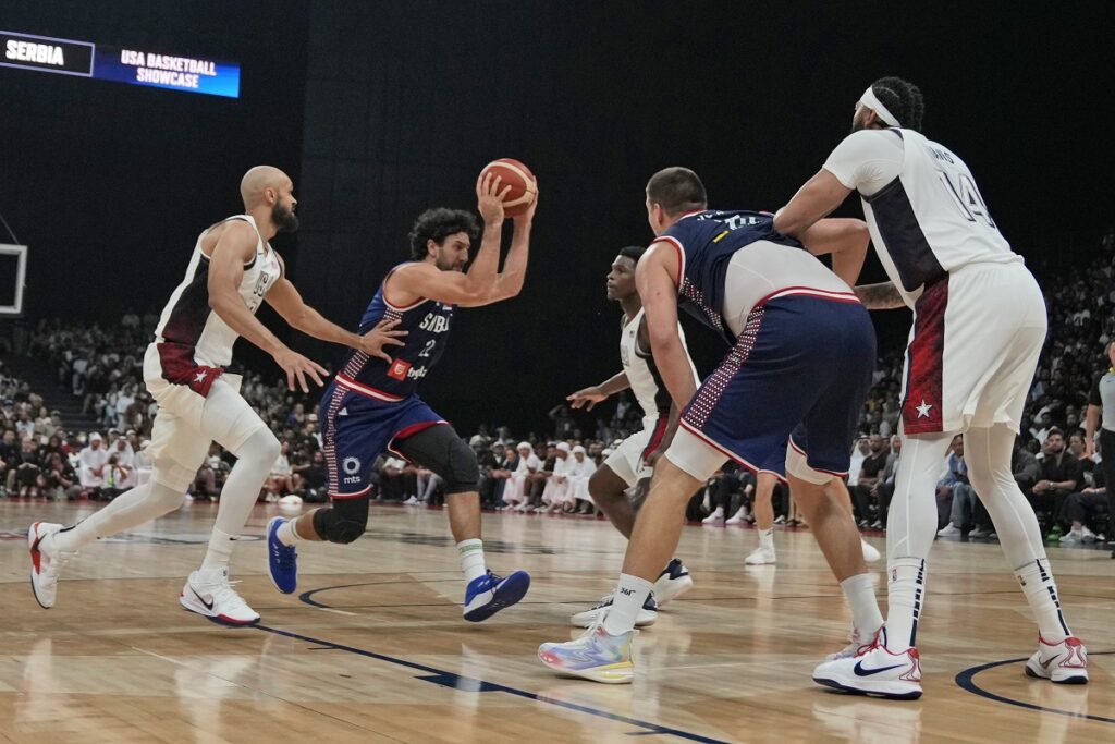 Serbia's Vasilije Micic, second left, drives to the basket during an exhibition basketball match between Serbia and the United States at the USA Basketball Showcase, ahead of the 2024 Paris Olympic basketball tournament, in Abu Dhabi, United Arab Emirates, Wednesday, July 17, 2024. (AP Photo/Altaf Qadri)