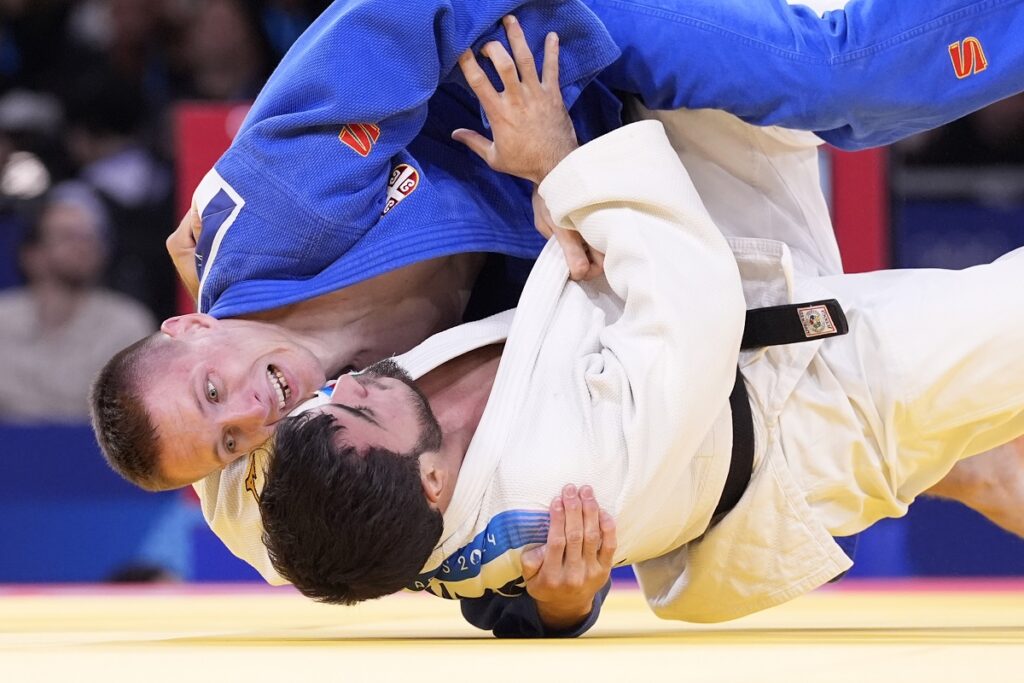 Azerbaijan's Yashar Najafov and Serbia's Strahinja Buncic, top, compete during their men -66 kg elimination round match in team judo competition at Champ-de-Mars Arena during the 2024 Summer Olympics, Sunday, July 28, 2024, in Paris, France. (AP Photo/Eugene Hoshiko)