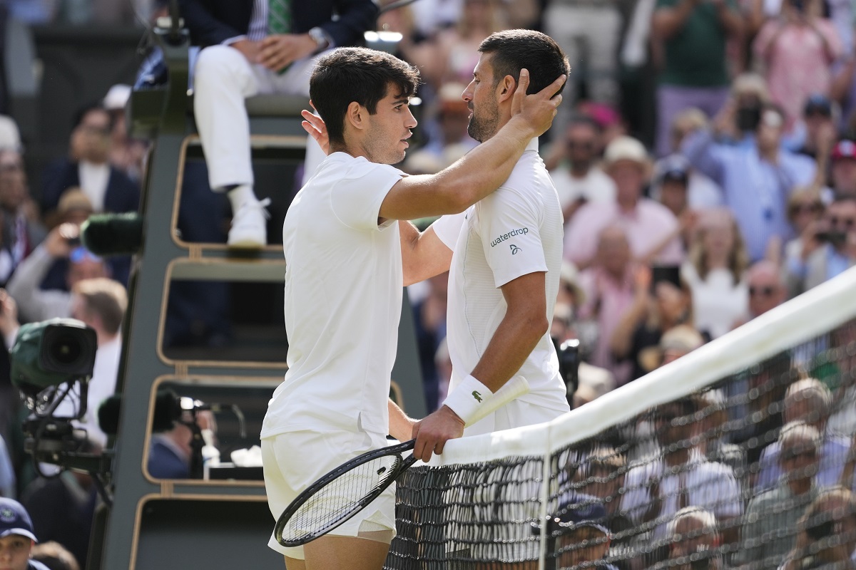 Carlos Alcaraz, left, of Spain is congratulated by Novak Djokovic of Serbia after winning the men's singles final at the Wimbledon tennis championships in London, Sunday, July 14, 2024. (AP Photo/Kirsty Wigglesworth)