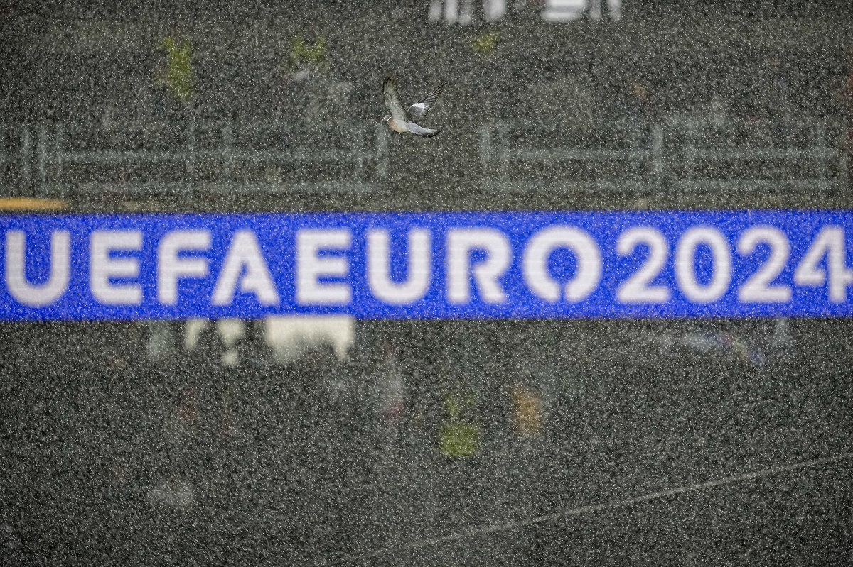 A pigeon flies through heavy rainfall before a semifinal match between the Netherlands and England at the Euro 2024 soccer tournament in Dortmund, Germany, Wednesday, July 10, 2024. (AP Photo/Andreea Alexandru)