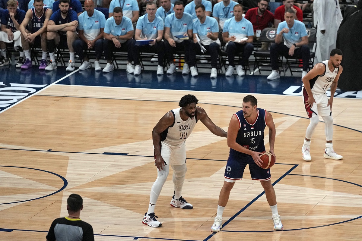 Serbia's Nikola Jokic, second right, attempts to score as United States' Joel Embiid tries to block him during an exhibition basketball match between Serbia and the United States at the USA Basketball Showcase, ahead of the 2024 Paris Olympic basketball tournament, in Abu Dhabi, United Arab Emirates, Wednesday, July 17, 2024. (AP Photo/Altaf Qadri)