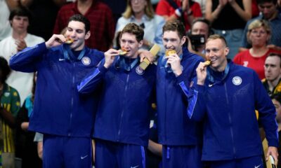 The United States men's 4x100-meter freestyle relay team celebrate as they stand on the podium after winning the gold medal at the 2024 Summer Olympics, Saturday, July 27, 2024, in Nanterre, France. (AP Photo/Petr David Josek)