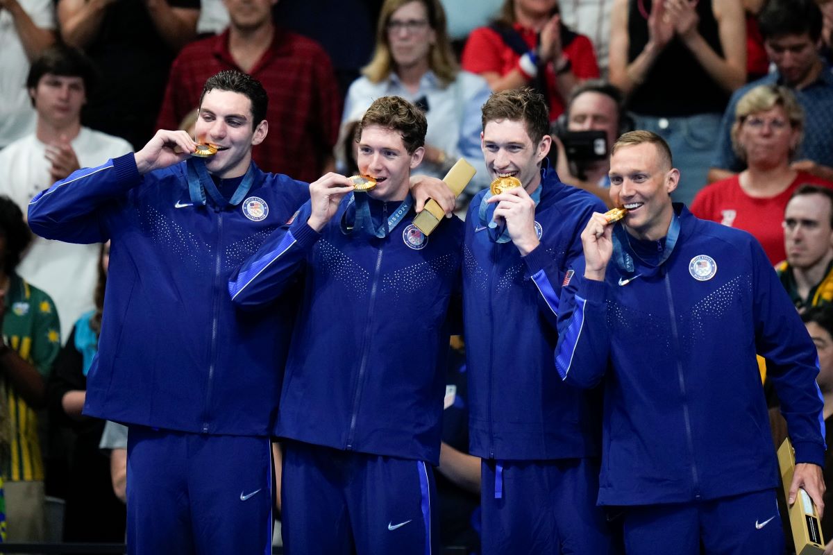 The United States men's 4x100-meter freestyle relay team celebrate as they stand on the podium after winning the gold medal at the 2024 Summer Olympics, Saturday, July 27, 2024, in Nanterre, France. (AP Photo/Petr David Josek)