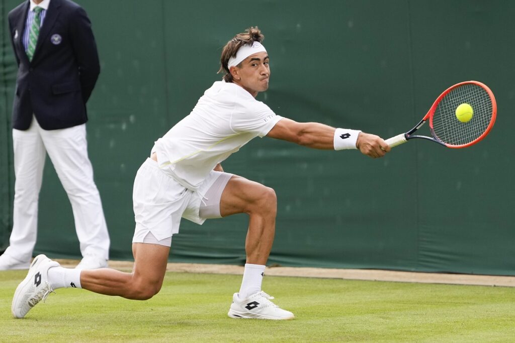 Francisco Comesana of Argentina plays a backhand return to Andrey Rublev of Russia during their first round match at the Wimbledon tennis championships in London, Tuesday, July 2, 2024. (AP Photo/Alberto Pezzali)