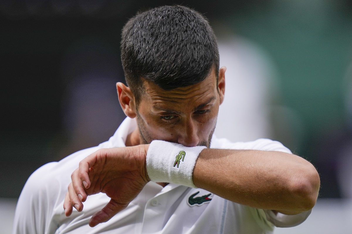 Novak Djokovic of Serbia wipes the sweat from his face during his match against Carlos Alcaraz of Spain in the men's singles final at the Wimbledon tennis championships in London, Sunday, July 14, 2024. (AP Photo/Alberto Pezzali)