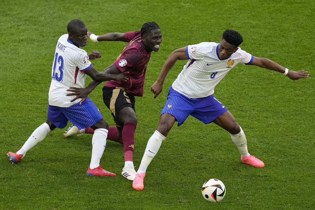 Belgium's Amadou Onana is challenged by N'Golo Kante of France and Aurelien Tchouameni of France during a round of sixteen match between France and Belgium at the Euro 2024 soccer tournament in Duesseldorf, Germany, Monday, July 1, 2024. (AP Photo/Andreea Alexandru)