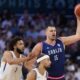 Nikola Jokic, of Serbia, looks to pass away from George Conditt IV, of Puerto Rico, in a men's basketball game at the 2024 Summer Olympics, Wednesday, July 31, 2024, in Villeneuve-d'Ascq, France. (AP Photo/Mark J. Terrill)