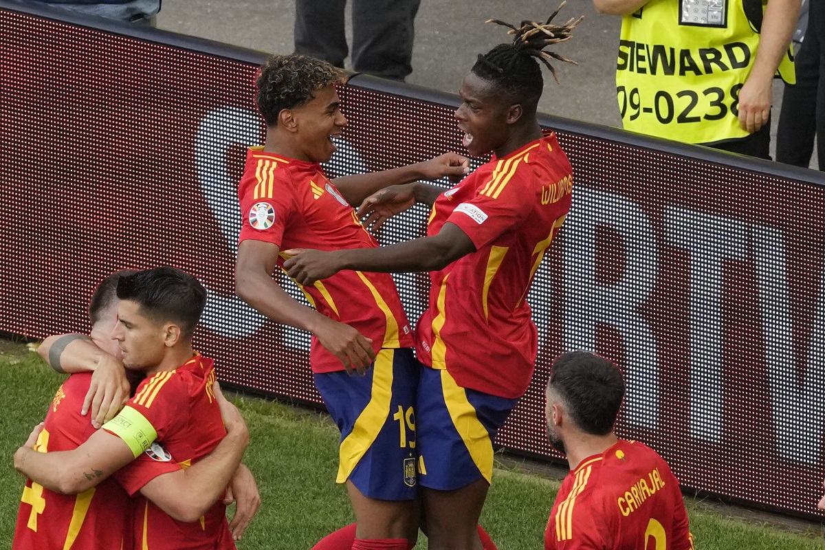 Spain's Lamine Yamal, top left celebrates with Spain's Nico Williams, top right and other team mates after Dani Olmo scored the opening goal during a quarter final match between Germany and Spain at the Euro 2024 soccer tournament in Stuttgart, Germany, Friday, July 5, 2024. (AP Photo/Michael Probst)