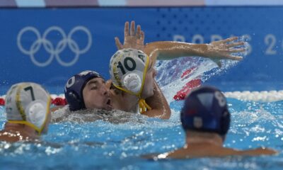 Serbia's Nemanja Ubovic, center left, and Australia's Marcus Berehulak, center right, battle for position during a men's water polo Group B preliminary match between Australia and Serbia at the 2024 Summer Olympics, Tuesday, July 30, 2024, in Saint-Denis, France. (AP Photo/Luca Bruno)