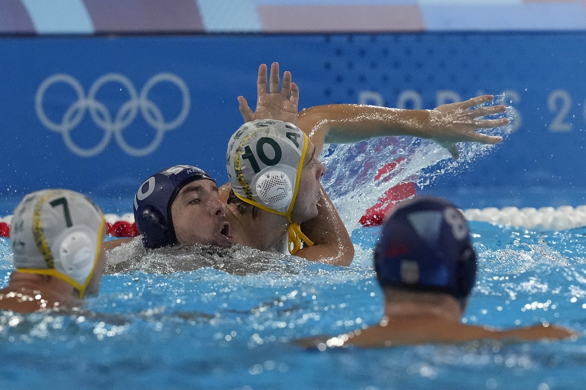 Serbia's Nemanja Ubovic, center left, and Australia's Marcus Berehulak, center right, battle for position during a men's water polo Group B preliminary match between Australia and Serbia at the 2024 Summer Olympics, Tuesday, July 30, 2024, in Saint-Denis, France. (AP Photo/Luca Bruno)