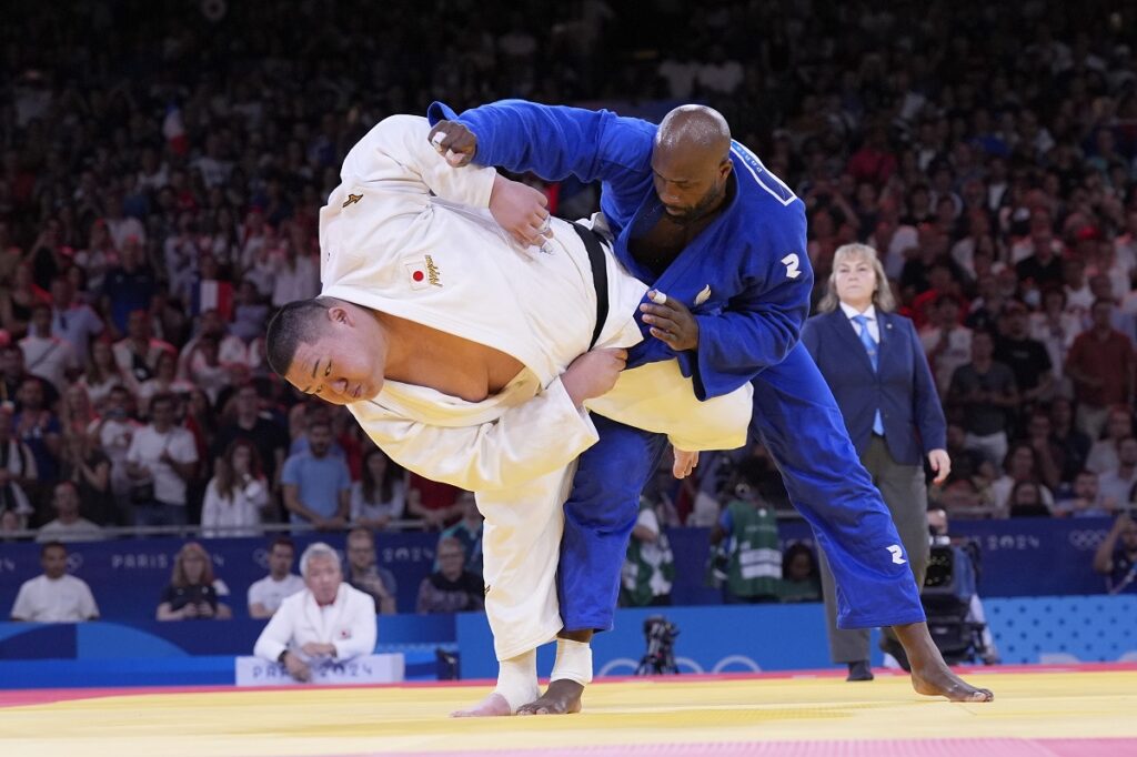 Japan's Tatsuru Saito and France's Teddy Riner compete during men's +90 kg of the mixed team final match in the team judo competition, at Champ-de-Mars Arena, during the 2024 Summer Olympics, Saturday, Aug. 3, 2024, in Paris, France. (AP Photo/Eugene Hoshiko)