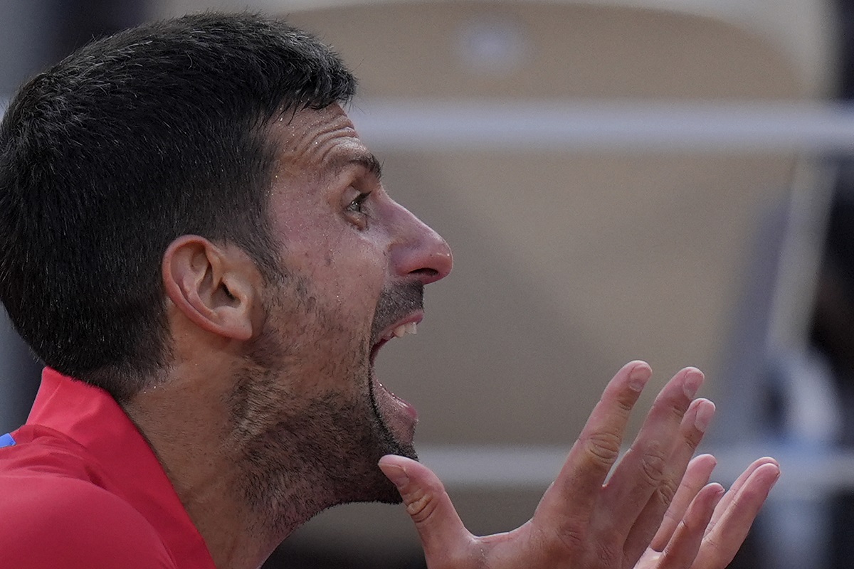 Novak Djokovic of Serbia reacts during a break as he plays against Lorenzo Musetti of Italy during their men's singles semifinals tennis match, at the 2024 Summer Olympics, Friday, Aug. 2, 2024, at the Roland Garros stadium in Paris, France. (AP Photo/Andy Wong)