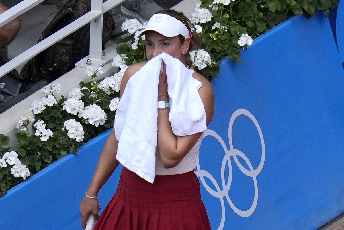 Croatia's Donna Vekic wipes her face as she plays China's Zheng Qinwen during the Women's Singles tennis final at the Roland Garros stadium at the 2024 Summer Olympics, Saturday, Aug. 3, 2024, in Paris, France. (AP Photo/Manu Fernandez)