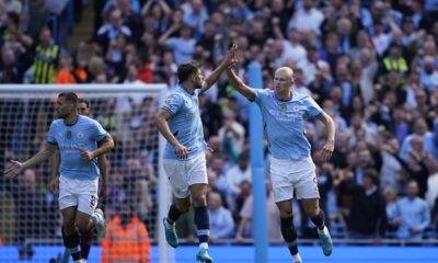 Manchester City's Erling Haaland, right, is congratulated by Ruben Dias after scoring his side's first goal from the penalty spot during the English Premier League soccer match between Manchester City and Ipswich Town at the Etihad Stadium in Manchester, England, Saturday, Aug. 24, 2024. (AP Photo/Dave Thompson)