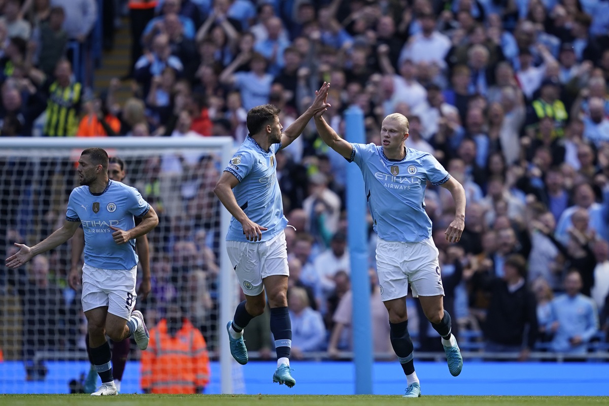 Manchester City's Erling Haaland, right, is congratulated by Ruben Dias after scoring his side's first goal from the penalty spot during the English Premier League soccer match between Manchester City and Ipswich Town at the Etihad Stadium in Manchester, England, Saturday, Aug. 24, 2024. (AP Photo/Dave Thompson)