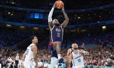 United States' LeBron James, center, goes up for a dunk as Puerto Rico's Tremont Waters, left, and Puerto Rico's Jose Alvarado defend during a men's basketball game at the 2024 Summer Olympics, Saturday, Aug. 3, 2024, in Villeneuve-d'Ascq, France. (AP Photo/Michael Conroy)