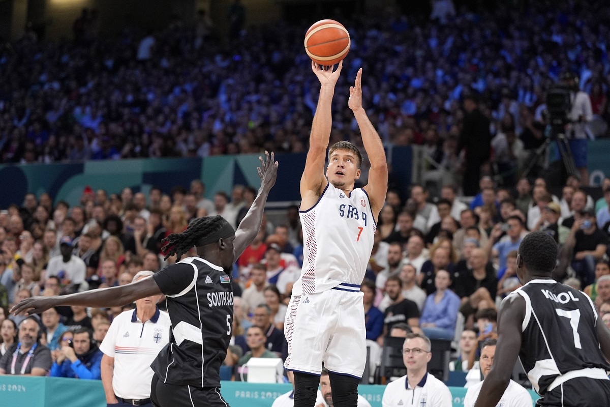 Serbia's Bogdan Bogdanovic, center, shoots as South Sudan's Nuni Omot, left, and South Sudan's Bul Kuol defend during a men's basketball game at the 2024 Summer Olympics, Saturday, Aug. 3, 2024, in Villeneuve-d'Ascq, France. (AP Photo/Michael Conroy)