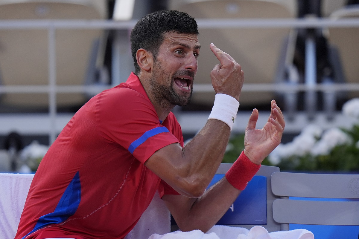 Novak Djokovic of Serbia reacts during a break as he plays against Lorenzo Musetti of Italy during their men's singles semifinals tennis match, at the 2024 Summer Olympics, Friday, Aug. 2, 2024, at the Roland Garros stadium in Paris, France. (AP Photo/Andy Wong)