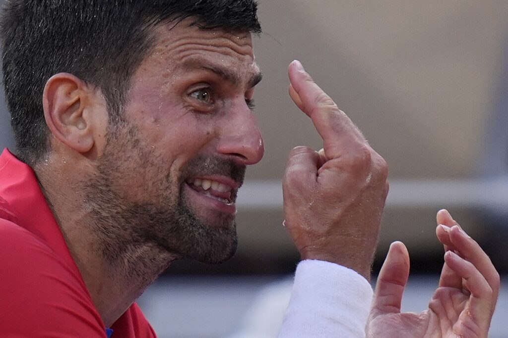 Novak Djokovic of Serbia reacts during a break as he plays against Lorenzo Musetti of Italy during their men's singles semifinals tennis match, at the 2024 Summer Olympics, Friday, Aug. 2, 2024, at the Roland Garros stadium in Paris, France. (AP Photo/Andy Wong)