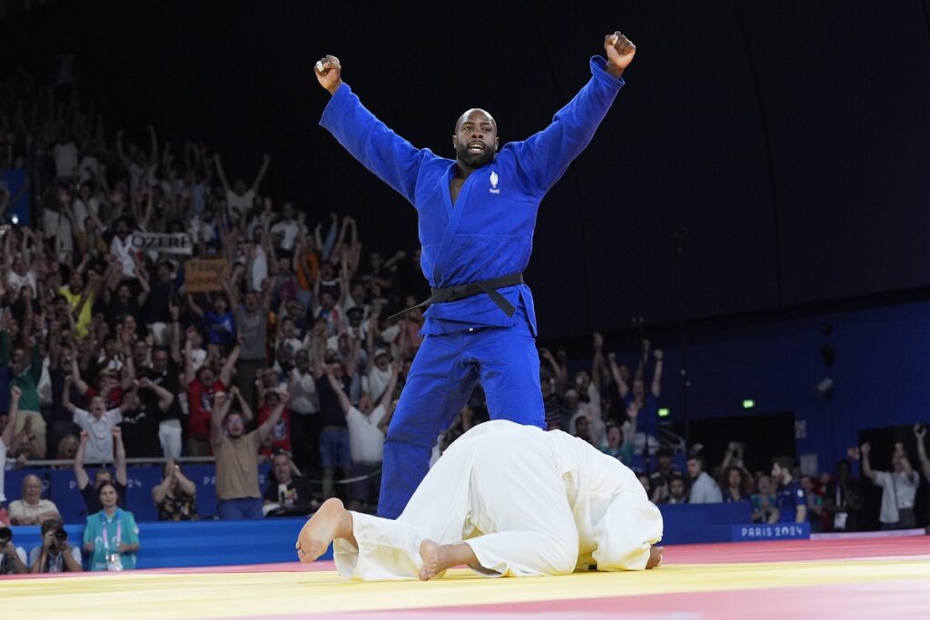 France's Teddy Riner celebrates after defeating South Korea's  Kim Min-jong during their men's +100 kg final match in the team judo competition, at Champ-de-Mars Arena, during the 2024 Summer Olympics, Friday, Aug. 2, 2024, in Paris, France. (AP Photo/Eugene Hoshiko)