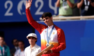 Spain's Carlos Alcaraz waves with his silver medal after losing to Serbia's Novak Djokovic in the men's singles tennis final at the Roland Garros stadium during the 2024 Summer Olympics, Sunday, Aug. 4, 2024, in Paris, France. Djokovic has won his first Olympic gold medal by beating Alcaraz 7-6 (3), 7-6 (2) in the 2024 Games men's tennis singles final. (AP Photo/Manu Fernandez)