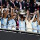 Manchester City midfielder Kevin De Bruyne lifts the trophy after his team won the FA Community Shield soccer match between Manchester City and Manchester United at Wembley Stadium in London, Saturday, Aug. 10, 2024. (AP Photo/David Cliff)