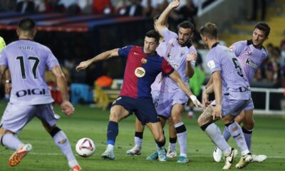 Barcelona's Robert Lewandowski, centre, passes the ball during the Spanish La Liga soccer match between FC Barcelona and Athletic Bilbao at the Olympic stadium in Barcelona, Spain, Saturday, Aug. 24, 2024. (AP Photo/Joan Monfort)