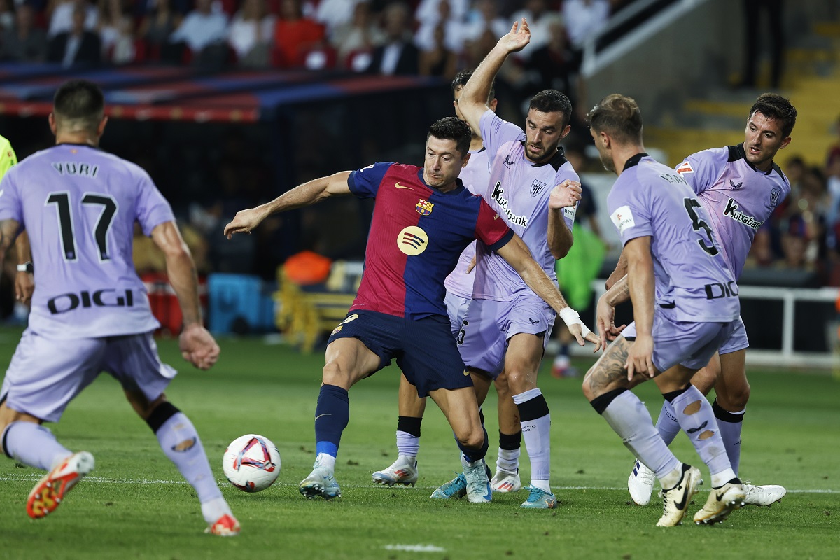 Barcelona's Robert Lewandowski, centre, passes the ball during the Spanish La Liga soccer match between FC Barcelona and Athletic Bilbao at the Olympic stadium in Barcelona, Spain, Saturday, Aug. 24, 2024. (AP Photo/Joan Monfort)