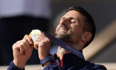 Serbia's Novak Djokovic watches his gold medal after defeating Spain's Carlos Alcaraz in the men's singles tennis final at the Roland Garros stadium during the 2024 Summer Olympics, Sunday, Aug. 4, 2024, in Paris, France. Djokovic has won his first Olympic gold medal by beating Alcaraz 7-6 (3), 7-6 (2) in the 2024 Games men's tennis singles final. (AP Photo/Manu Fernandez)