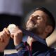 Serbia's Novak Djokovic watches his gold medal after defeating Spain's Carlos Alcaraz in the men's singles tennis final at the Roland Garros stadium during the 2024 Summer Olympics, Sunday, Aug. 4, 2024, in Paris, France. Djokovic has won his first Olympic gold medal by beating Alcaraz 7-6 (3), 7-6 (2) in the 2024 Games men's tennis singles final. (AP Photo/Manu Fernandez)