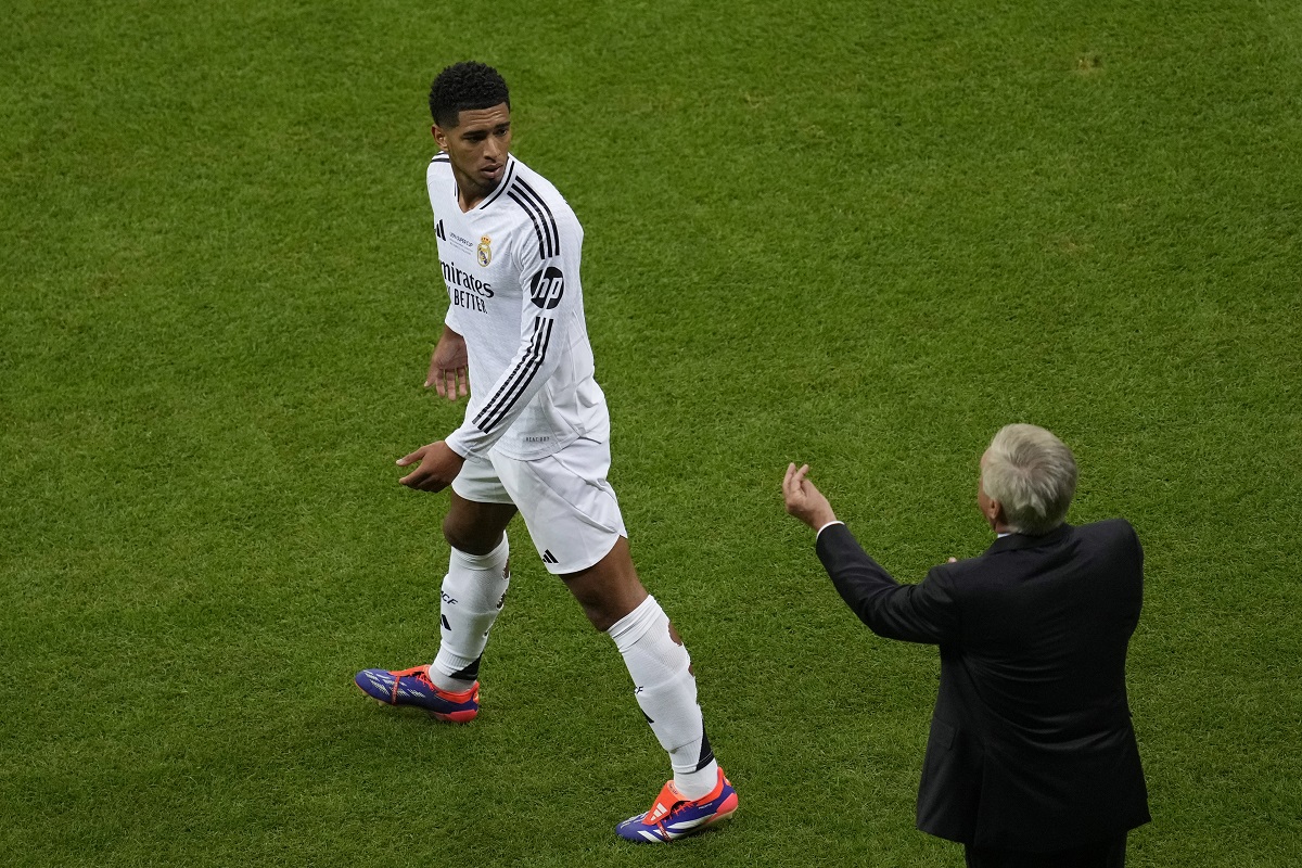 Real Madrid's Jude Bellingham, left, listens to his head coach Carlo Ancelotti during the UEFA Super Cup Final soccer match between Real Madrid and Atalanta at the Narodowy stadium in Warsaw, Poland, Wednesday, Aug. 14, 2024. (AP Photo/Darko Vojinovic)