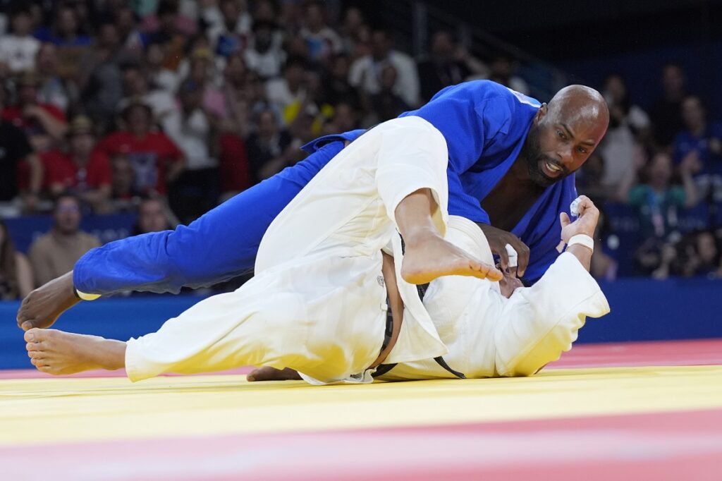 South Korea's Min-Jong Kim and France's Teddy Riner compete during their men's +100 kg final match in the team judo competition, at Champ-de-Mars Arena, during the 2024 Summer Olympics, Friday, Aug. 2, 2024, in Paris, France. (AP Photo/Eugene Hoshiko)