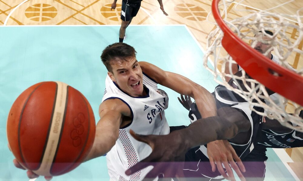 Serbia's Bogdan Bogdanovic, left, shoots as South Sudan's Majok Deng defends during a men's basketball game at the 2024 Summer Olympics, Saturday, Aug. 3, 2024, in Villeneuve-d'Ascq, France. (Gregory Shamus/Pool Photo via AP)