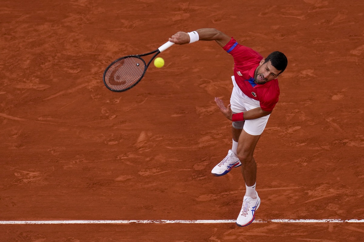 Novak Djokovic of Serbia serves against Lorenzo Musetti of Italy in their men's singles semifinals tennis match, at the 2024 Summer Olympics, Friday, Aug. 2, 2024, at the Roland Garros stadium in Paris, France. (AP Photo/Manu Fernandez)