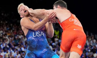 Serbia's Hetik Cabolov and Kyle Douglas Dake, of the United States, in blue, compete during their men's freestyle 74kg bronze medal wrestling match, at Champ-de-Mars Arena, during the 2024 Summer Olympics, Saturday, Aug. 10, 2024, in Paris, France. (AP Photo/Eugene Hoshiko)