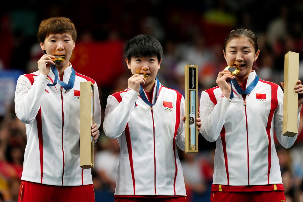 China athletes with the gold medals pose during the medal ceremony of the women's team table tennis match at the 2024 Summer Olympics, Saturday, Aug. 10, 2024, in Paris, France. (AP Photo/Petros Giannakouris)