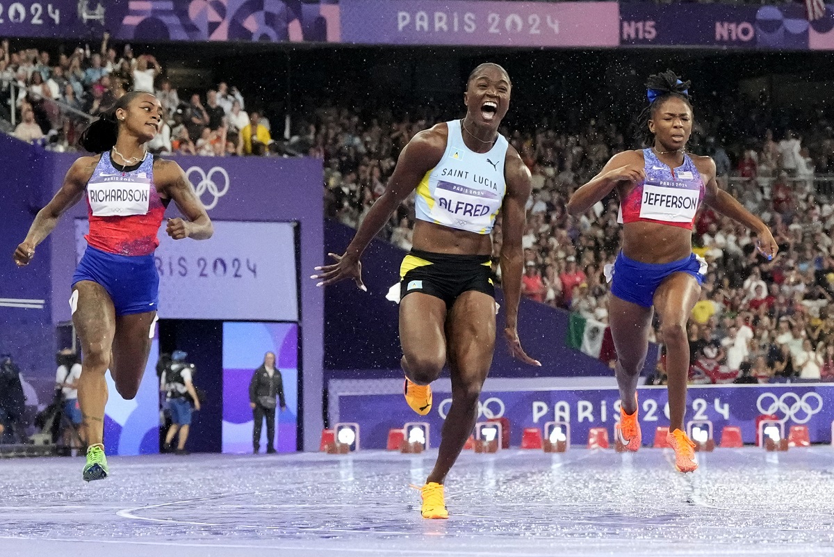 Julien Alfred, of Saint Lucia, celebrates after winning the women's 100-meter final at the 2024 Summer Olympics, Saturday, Aug. 3, 2024, in Saint-Denis, France. (AP Photo/David J. Phillip)