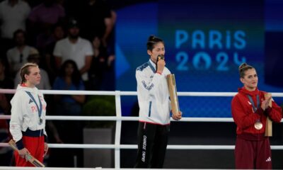 Gold medalist Taiwan's Lin Yu-ting, center, kisses her medal during a ceremony for the women's 57 kg final boxing match at the 2024 Summer Olympics, Saturday, Aug. 10, 2024, in Paris, France. (AP Photo/Ariana Cubillos)