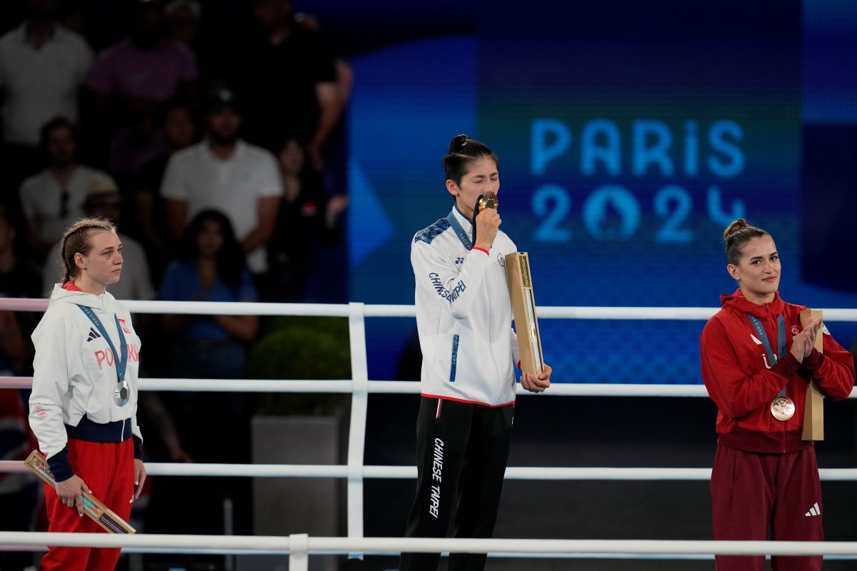 Gold medalist Taiwan's Lin Yu-ting, center, kisses her medal during a ceremony for the women's 57 kg final boxing match at the 2024 Summer Olympics, Saturday, Aug. 10, 2024, in Paris, France. (AP Photo/Ariana Cubillos)