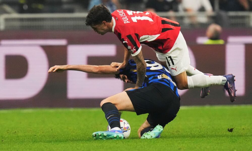 AC Milan's Christian Pulisic, top, and Inter Milan's Alessandro Bastoni challenge for the ball during the Serie A soccer match between Inter Milan and AC Milan at the San Siro stadium in Milan, Italy, Sunday, Sept.22, 2024. (AP Photo/Luca Bruno)