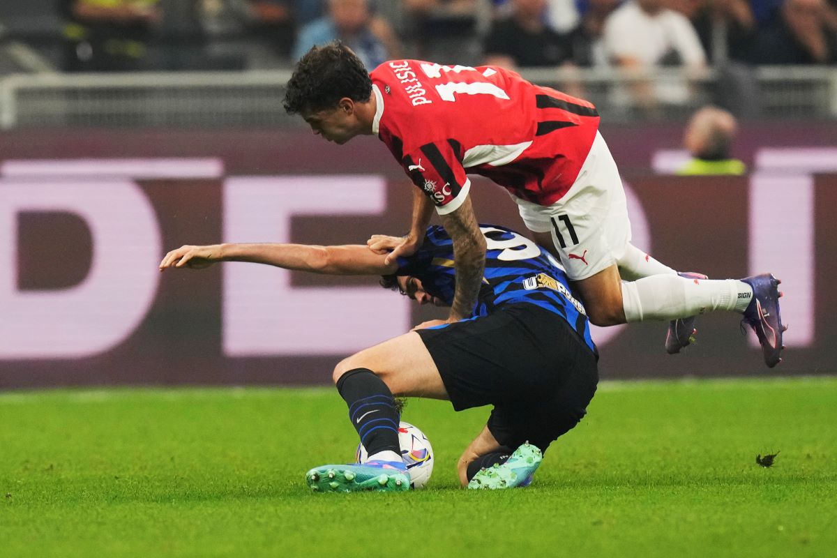 AC Milan's Christian Pulisic, top, and Inter Milan's Alessandro Bastoni challenge for the ball during the Serie A soccer match between Inter Milan and AC Milan at the San Siro stadium in Milan, Italy, Sunday, Sept.22, 2024. (AP Photo/Luca Bruno)