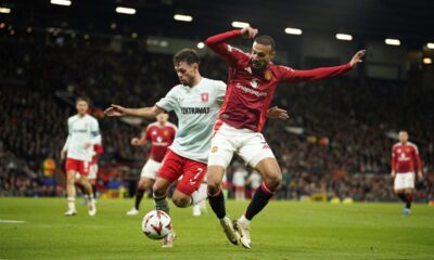 Manchester United's Noussair Mazraoui, right, and Twente's Mitchell van Bergen challenge for the ball during the Europa League opening phase soccer match between Manchester United and Twente in Manchester, England, Wednesday, Sept. 25, 2024. (AP Photo/Dave Thompson)