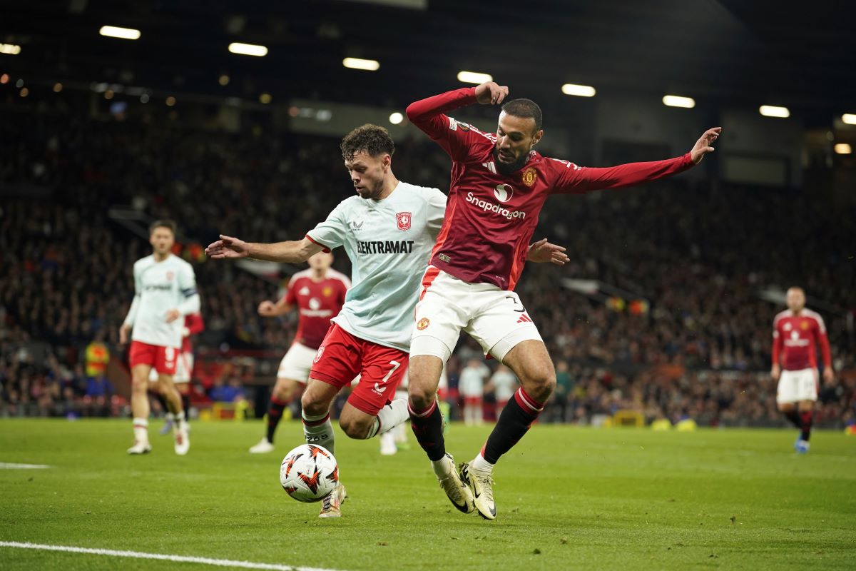 Manchester United's Noussair Mazraoui, right, and Twente's Mitchell van Bergen challenge for the ball during the Europa League opening phase soccer match between Manchester United and Twente in Manchester, England, Wednesday, Sept. 25, 2024. (AP Photo/Dave Thompson)