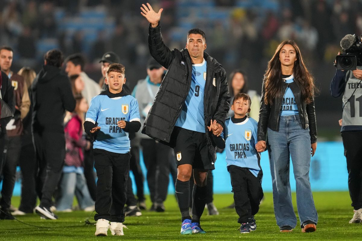 Uruguay's Luis Suarez waves to fans, accompanied by his children, after a qualifying soccer match for the FIFA World Cup 2026 against Paraguay, in Montevideo, Uruguay, Friday, Sept. 6, 2024. Suarez played his last game for Uruguay ending a 17 years international carrer. (AP Photo/Matilde Campodonico)