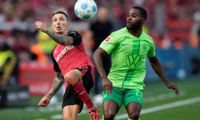 Leverkusen's Alex Grimaldo, left, and Wolfsburg's Ridle Baku fight for the ball during the German Bundesliga soccer match between Bayer Leverkusen and VfL Wolfsburg at the BayArena in Leverkusen, Germany, Sunday, Sept. 22, 2024. (AP Photo/Martin Meissner)