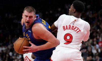 Denver Nuggets centre Nikola Jokic, left, tries to get past Toronto Raptors guard RJ Barrett (9) during second-half NBA basketball game action in Toronto, Monday, Oct. 28, 2024. (Nathan Denette/The Canadian Press via AP)