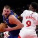 Denver Nuggets centre Nikola Jokic, left, tries to get past Toronto Raptors guard RJ Barrett (9) during second-half NBA basketball game action in Toronto, Monday, Oct. 28, 2024. (Nathan Denette/The Canadian Press via AP)