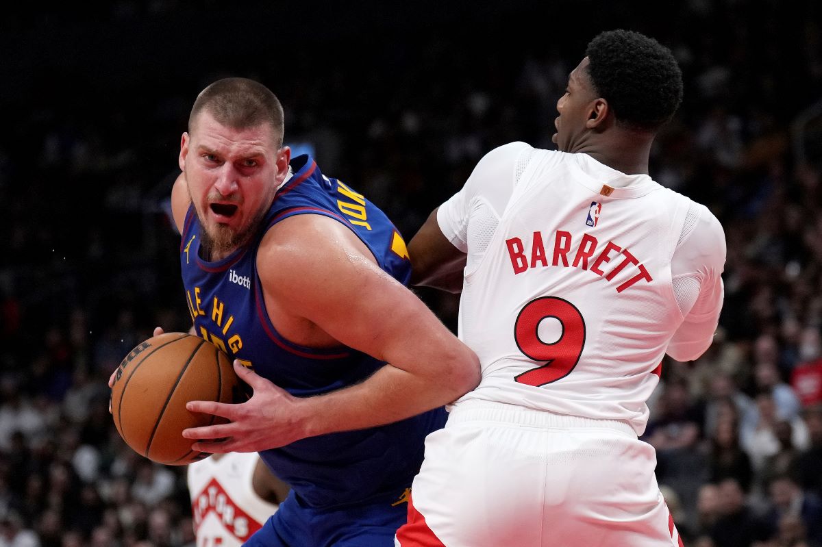 Denver Nuggets centre Nikola Jokic, left, tries to get past Toronto Raptors guard RJ Barrett (9) during second-half NBA basketball game action in Toronto, Monday, Oct. 28, 2024. (Nathan Denette/The Canadian Press via AP)