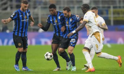 Inter Milan's Hakan Calhanoglu, second right, duels for the ball with Red Star's Cherif Ndiaye, right, during the Champions League opening phase soccer match between Inter Milan and Red Star, at the San Siro stadium in Milan, Italy, Tuesday, Oct. 1, 2024. (AP Photo/Luca Bruno)