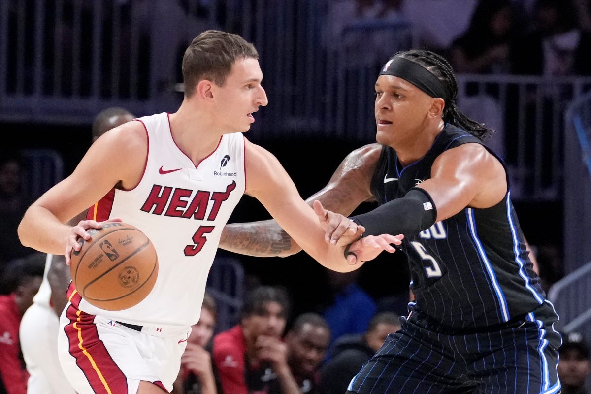 Miami Heat forward Nikola Jovic, left, drives up against Orlando Magic forward Paolo Banchero during the first half of an NBA basketball game, Wednesday, Oct. 23, 2024, in Miami. (AP Photo/Wilfredo Lee)